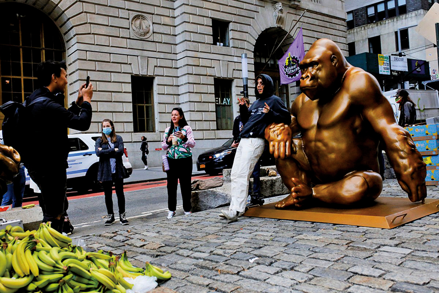 2021年10月18日，美國紐約華爾街銅牛前方豎起大猩猩哈蘭比（Harambe）的銅像，有遊客在現場拍照。（Michael M. Santiago/Getty Images）