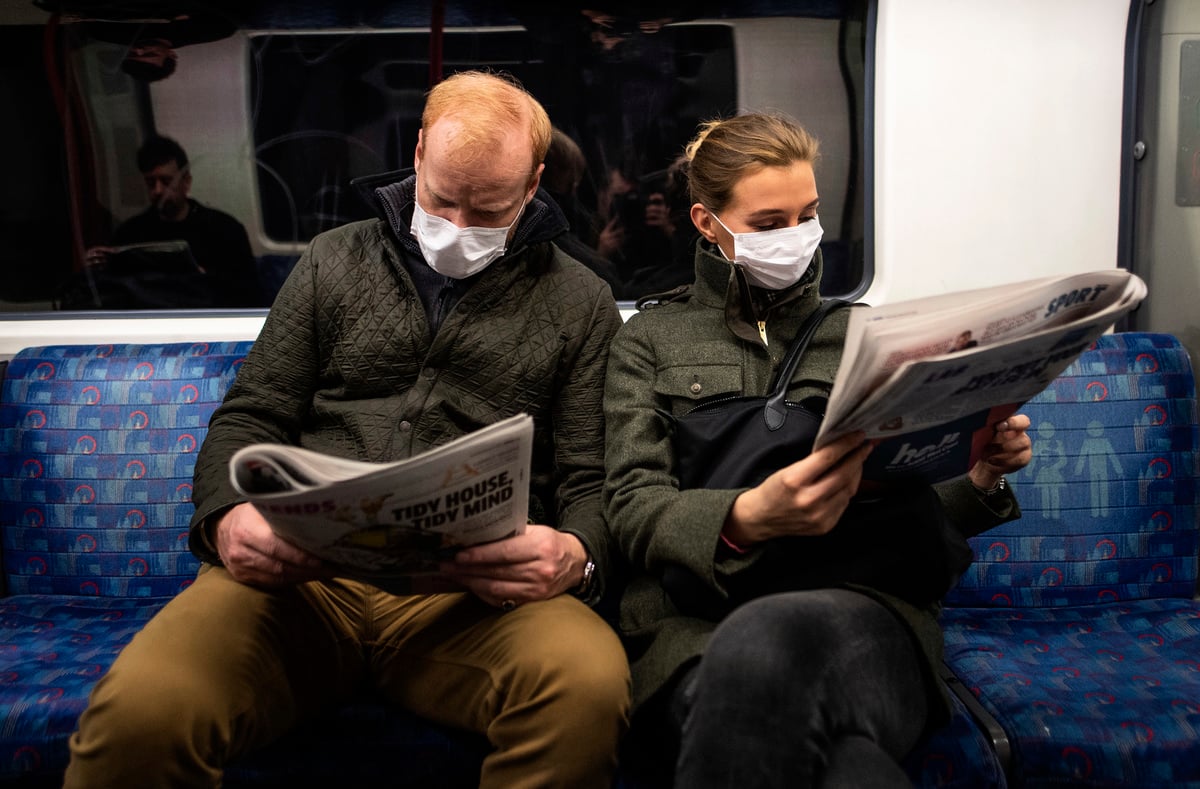 越來越多歐洲國家取消嚴厲的防疫措施。英國、西班牙和愛爾蘭政府將採取開放的態度來面對疫情，並取消嚴格的防疫規定。圖為防疫限制解除前，兩名戴口罩乘客在倫敦地鐵列車上看報紙。（Justin Setterfield/Getty Images）
