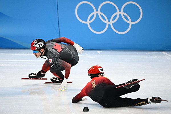 短道速滑男子5,000米接力半決賽中，李文龍與加拿大選手帕斯卡爾‧迪翁（Pascal Dion）冰刀相碰後，摔出賽道。 (Anne-Christine Poujoulat/AFP via Getty Images)