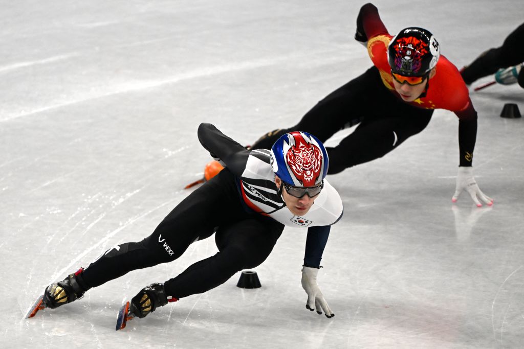 在北京冬奧會2月7日晚進行的短道速滑男子1,000米比賽上，韓國選手黃大憲和李俊瑞在半決賽中接連被判犯規，並被取消成績。韓國輿論強烈質疑比賽判罰不公。圖為當天半決賽上，黃大憲和中國選手任子威展開對決。（MANAN VATSYAYANA/AFP via Getty Images）