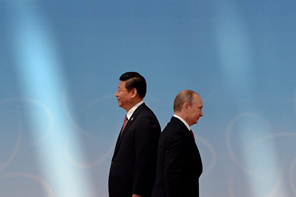圖為2014年5月，習近平與普京在亞信第4次峰會上擦肩而過。（Mark Ralston/AFP)