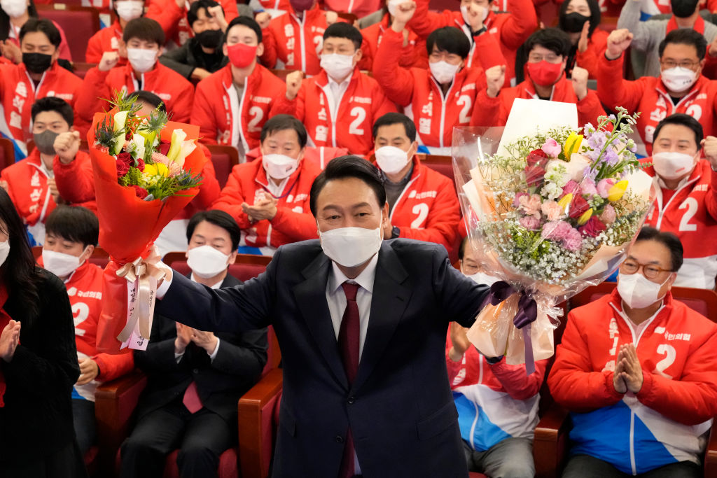 2022年3月10日，尹錫悅在首爾的國民議會上與人民力量黨黨員和立法者一起慶祝勝利。（Lee Jin-Man - Pool/Getty Images）