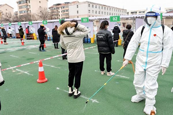 Omicron變異病毒在中國快速擴散之際，中共把來源「推卸」給韓國進口服裝。圖為2022年1月12日，天津市民排隊做核酸檢測。（STR/AFP via Getty Images）