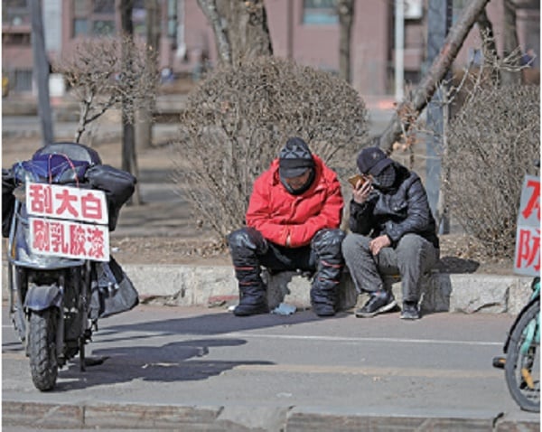日益加大的城鄉差距，和中共高喊的「共同富裕」背道而馳。2021年2月25日，遼寧省瀋陽市，農民工在路邊招攬工作。(STR/AFP)