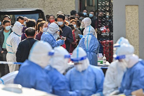 近日上海市也因疫情失控而封城。圖為2022年3月23日，上海市民排隊進行檢測核酸。（Hector Retamal /AFP via Getty Images）