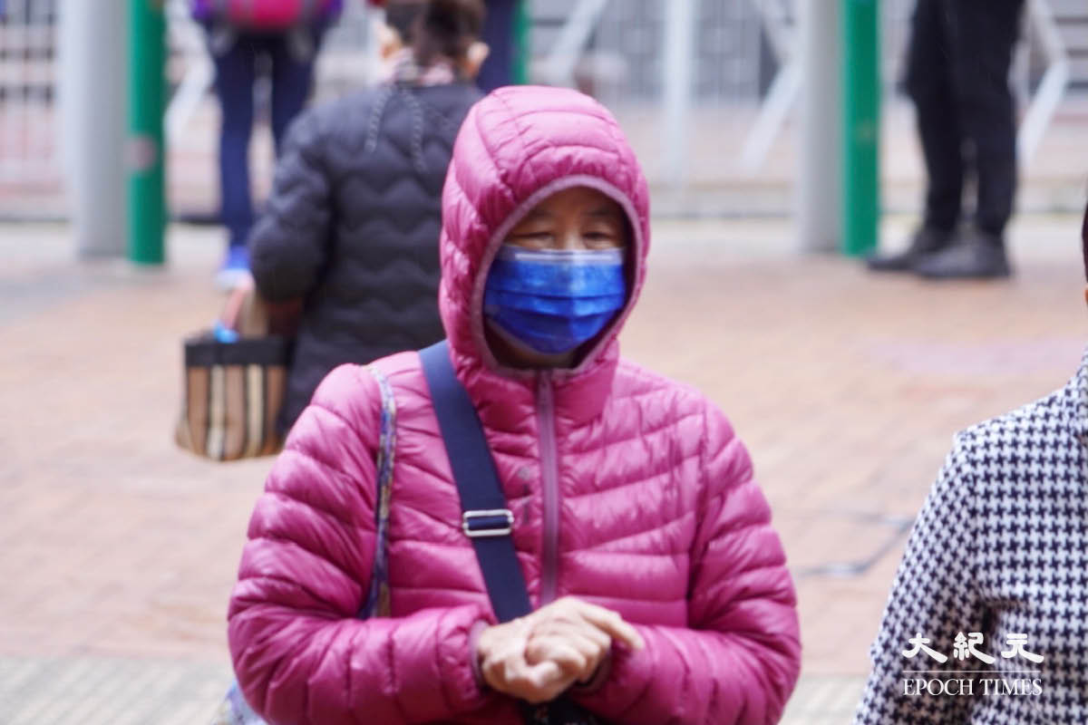 今日（4月2日）香港氣溫驟降，有市民外出穿上羽絨外套。（余鋼／大紀元）