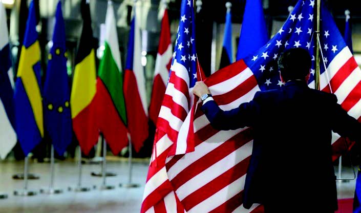 3月24日，布魯塞爾召開歐洲理事會會議，工作人員正準備展示歐洲和美國的國旗。（AFP）