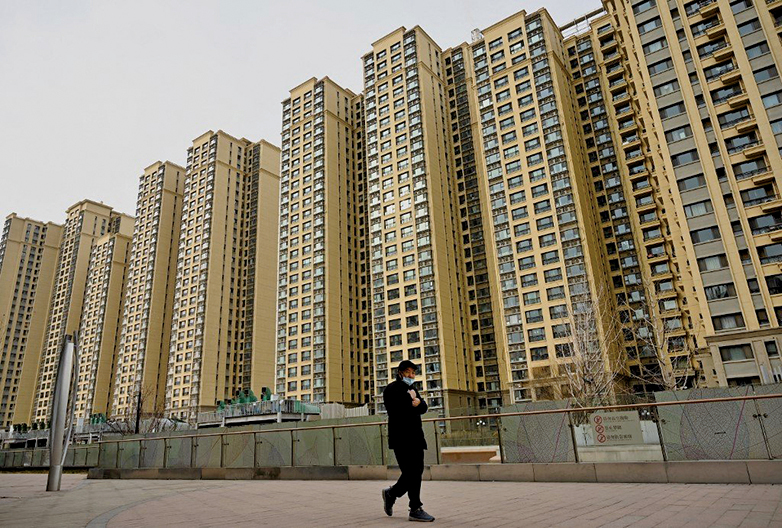 2021年12月8日，一名男子走過中國房地產開發商恒大在北京的住宅區。（Noel Celis/AFP）