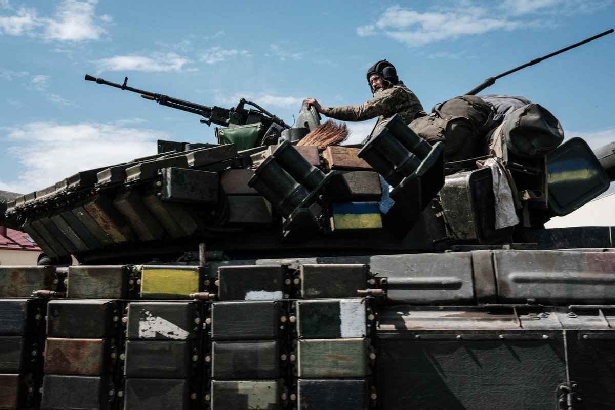 2022 年5月12日，在烏克蘭東部巴赫穆特附近一名烏克蘭士兵坐在一輛運輸車托運的坦克上。（Yasuyoshi CHIBA / AFP）