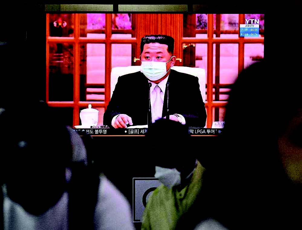 北韓爆發疫情，金正恩下達全國封鎖令。圖為5月12日，在南韓首爾火車站，人們坐在電視屏幕前，觀看北韓領導人金正恩首次戴著口罩出現在電視新聞報道中。（AFP）