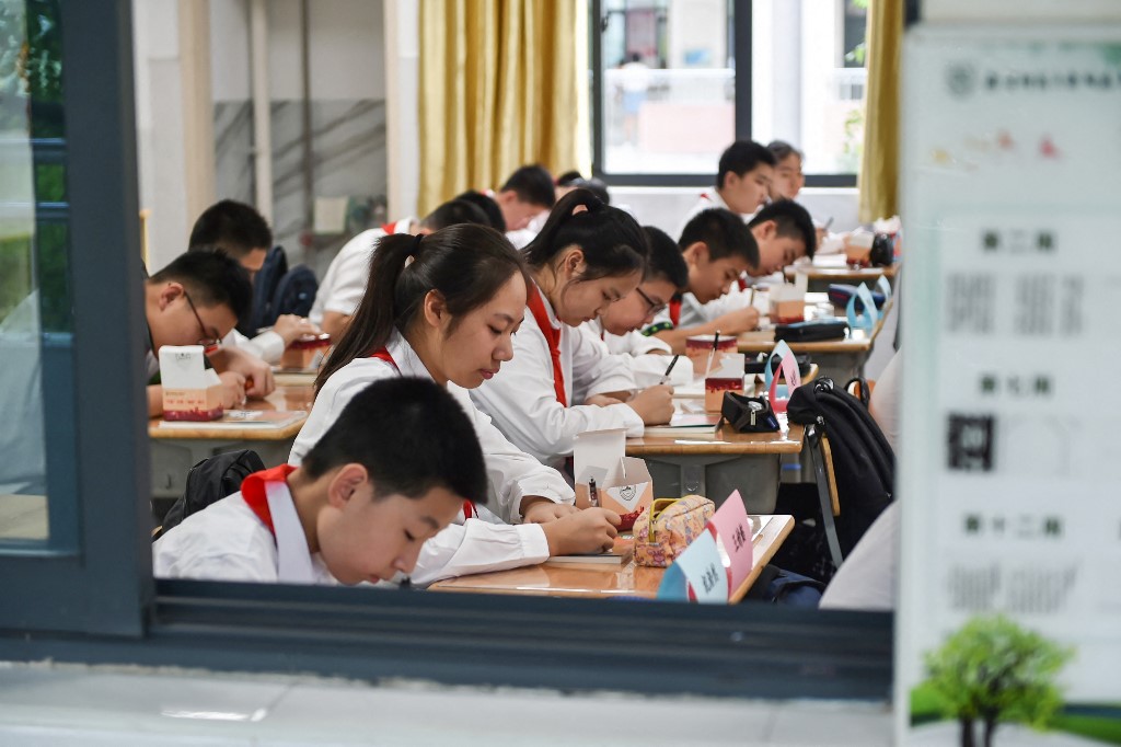 中共教育部要求中小學生「學工學農」，分階從事各種生活、生產勞動。圖為中國學生。（STR / AFP）