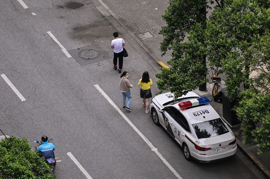 圖為2022年5月19日，在疫情封鎖期間，在街上行走的上海靜安區民眾。（Hector RETAMAL / AFP）