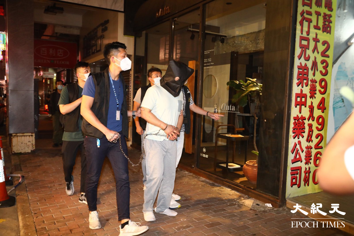 晚上8時許，大批警員押解一名疑犯，返回砵蘭街299號兇案現場。逗留大約五分鐘後離開。（胡琪／大紀元）