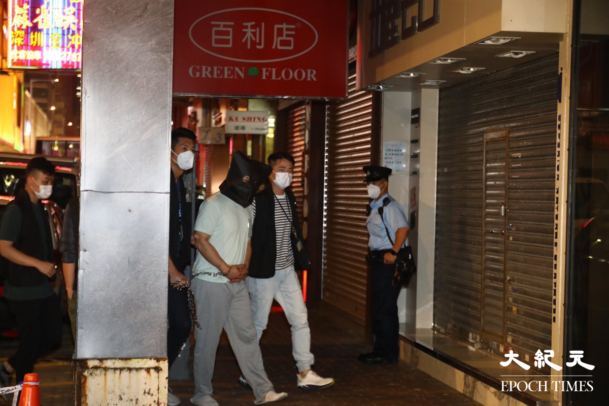 晚上8時許，大批警員押解一名疑犯，返回砵蘭街299號兇案現場。逗留大約五分鐘後離開。（胡琪／大紀元）
