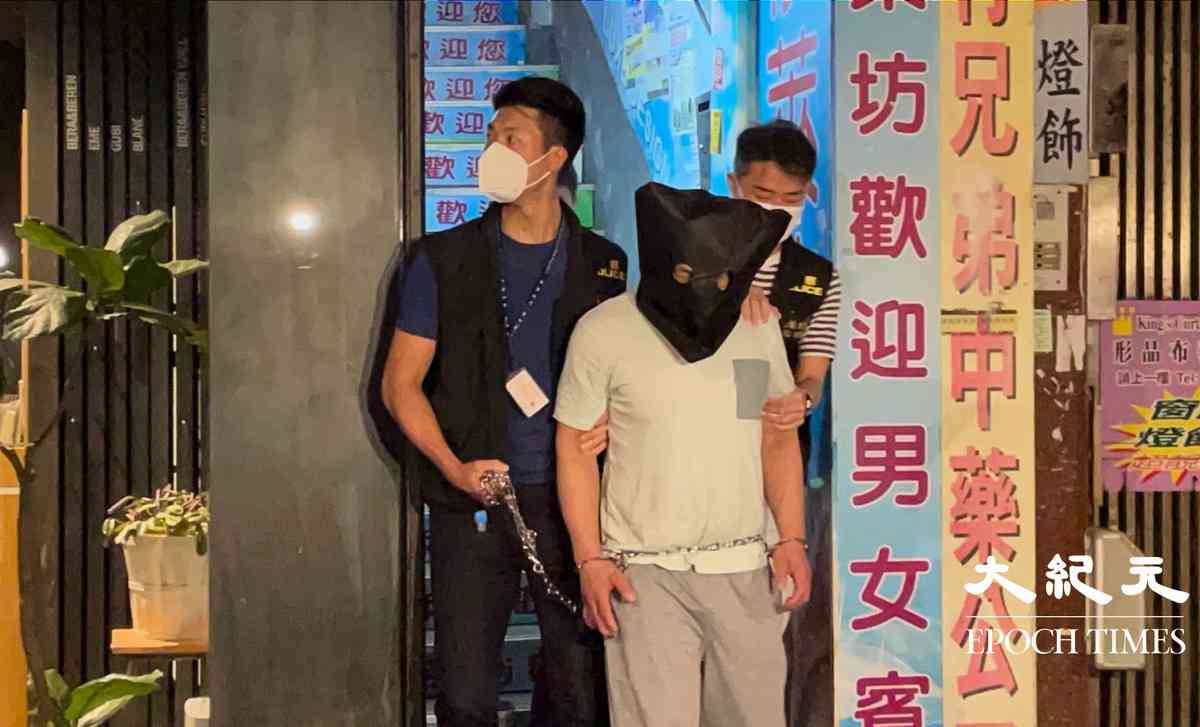 晚上8時許，大批警員押解一名疑犯，返回砵蘭街299號兇案現場。逗留大約五分鐘後離開。（卓相如／大紀元）