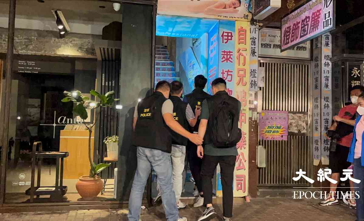 晚上8時許，大批警員押解一名疑犯，返回砵蘭街299號兇案現場。逗留大約五分鐘後離開。（卓相如／大紀元）