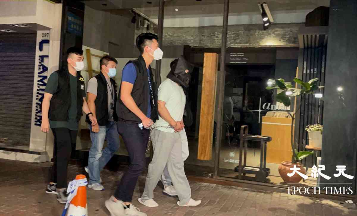 晚上8時許，大批警員押解一名疑犯，返回砵蘭街299號兇案現場。逗留大約五分鐘後離開。（卓相如／大紀元）