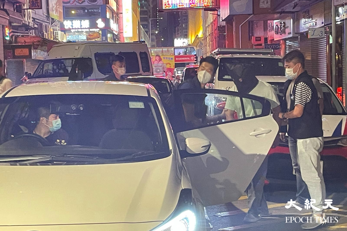 晚上8時許，大批警員押解一名疑犯，返回砵蘭街299號兇案現場。逗留大約五分鐘後離開。（卓相如／大紀元）