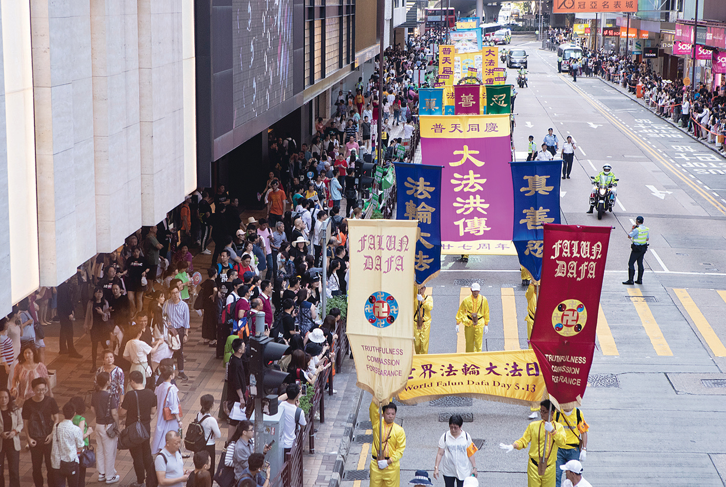 2019年5月12日，香港法輪功學員舉行集會遊行，慶祝世界法輪大法日。遊行隊伍途經尖沙咀廣東道，大批遊客和市民夾道觀看。（余鋼／大紀元）