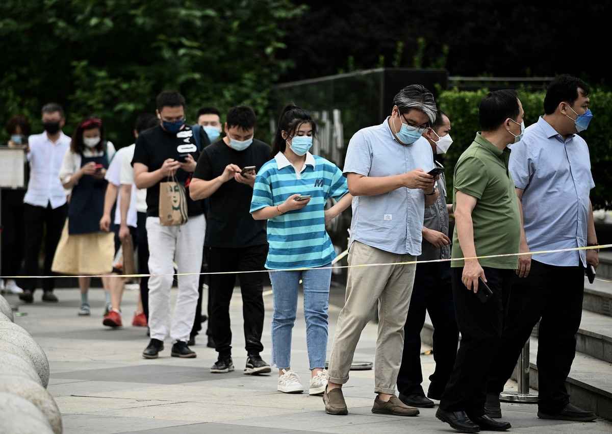 2022年6月14日，人們在北京的一個核酸檢測採集點前排隊等待。（Noel Celis / AFP）