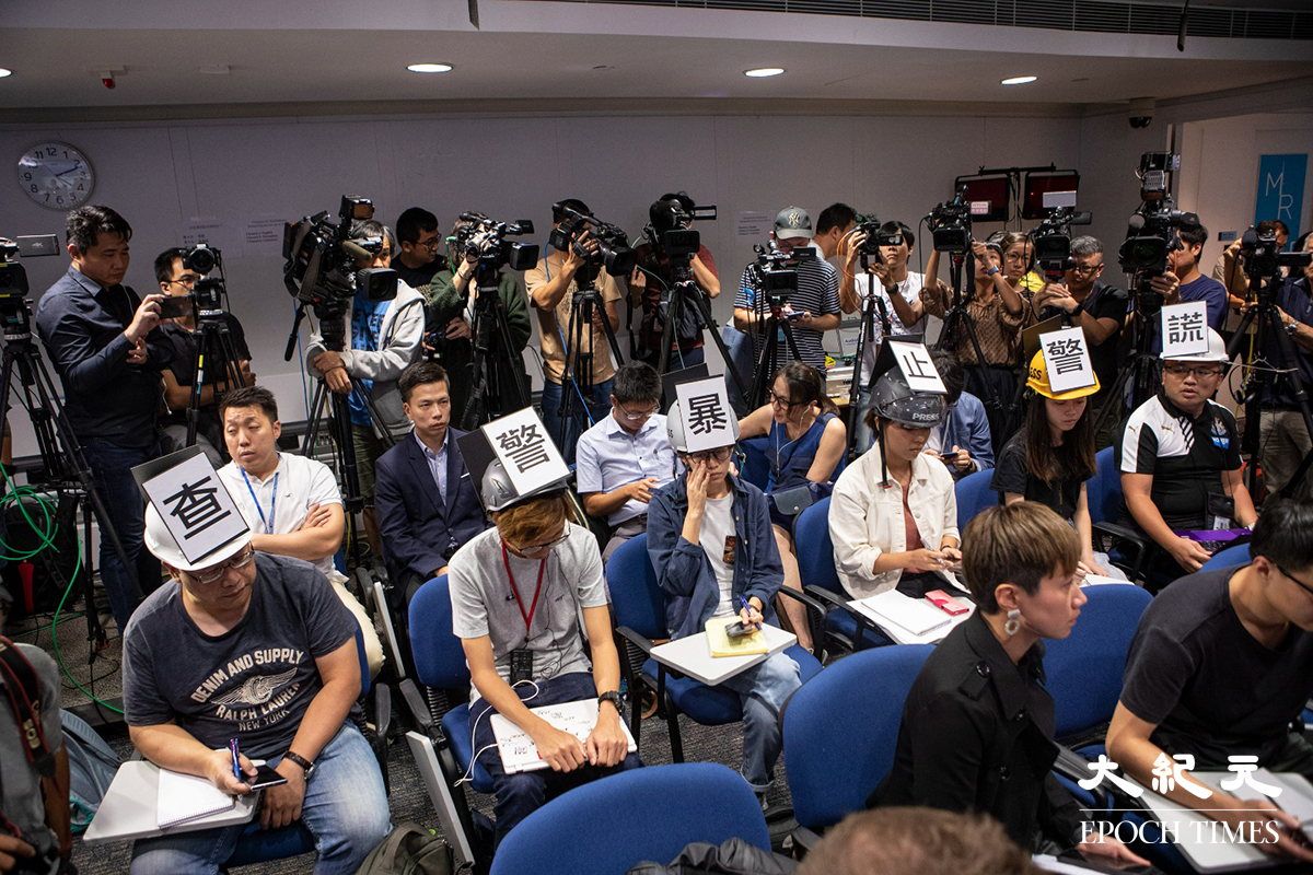 2019年11月4日，有6間傳媒記者於警方例行記者會上，戴上貼有「查警暴止警謊」標語的頭盔靜默抗議，被警方驅逐離開，後來更宣布取消記者會。（余鋼／大紀元）