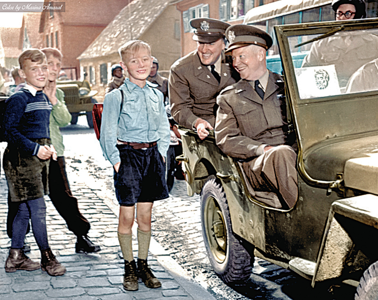 艾森豪威爾將軍和部下乘坐吉普車駛過德國一小學時，向三個德國小學生微笑。（Marina Amaral）