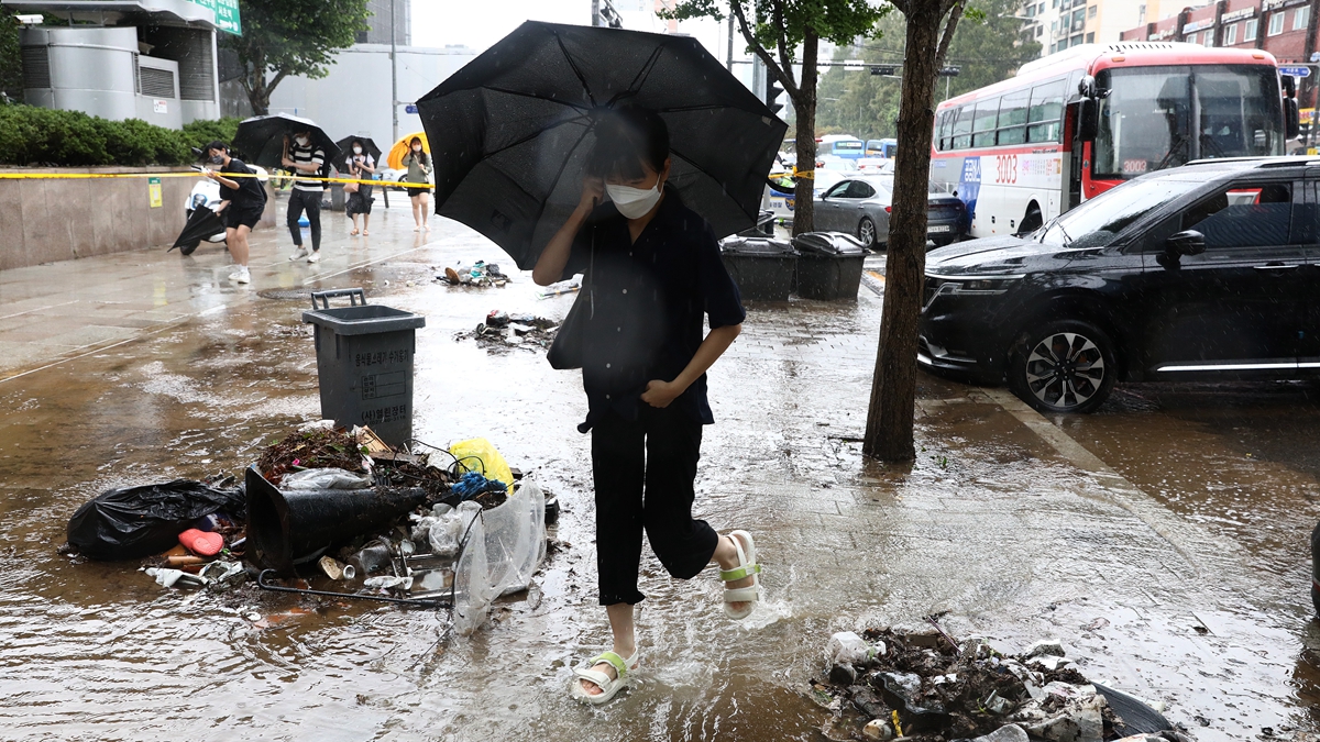 8月9日，南韓首爾，大雨過後人 們在街上行走。（Getty Images）