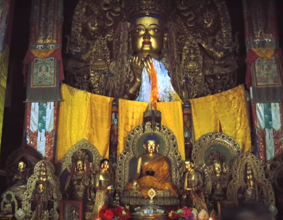 圖中後面是在拉卜楞寺中供奉的餾金彌勒佛銅像，被稱為「未來佛」。而在彌勒佛正前方的佛像是釋迦牟尼，稱為「現在佛」，衪們一先一後下世拯救蒼生。（未解之謎影片截圖）