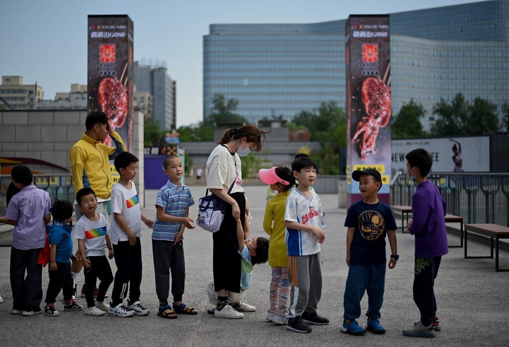 一些中國父母對孩子身高的焦慮，導致他們不惜花費巨資、不顧可能的副作用，給沒有適應症的正常兒童使用生長激素。圖為2021年6月1日，北京兒童在排隊玩滑梯。（Noel Celis / AFP）