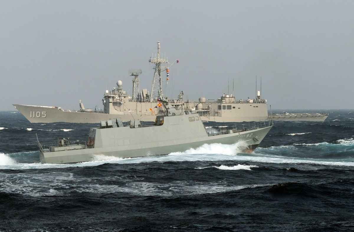 2014年1月14日，在高雄南部附近海域，台灣製造的光華六號快艇駛過一艘美國護衛艦旁。（SAM YEH/AFP via Getty Images）
