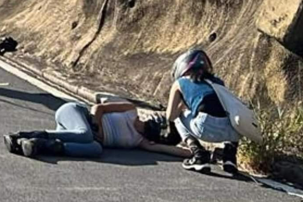 意外發生後，石澳道交通停頓，女電單車司機倒臥路上，有在場市民上前了解情況。(Facebook群組「交通意外圖片區 」圖片)