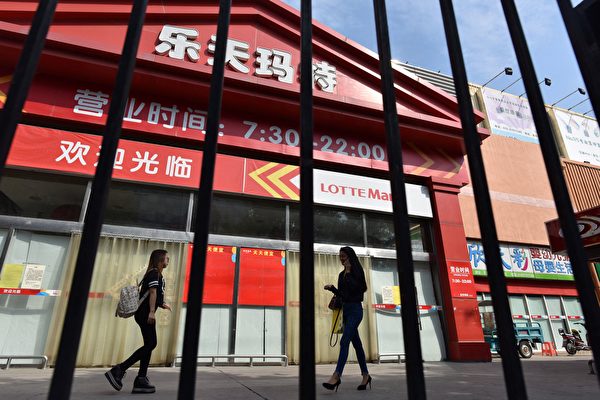 因薩德事件，韓企樂天在中國受到的打擊最大，苦撐5年後終於拋棄中國市場。圖為2017年9月15日，人們走過北京一家關門的樂天商店。（Greg Baker/AFP）
