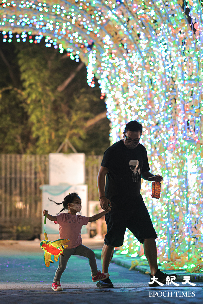小朋友在牛頭角佐敦谷水道的花燈隧道帶上燈籠玩耍。（陳仲明／大紀元）
