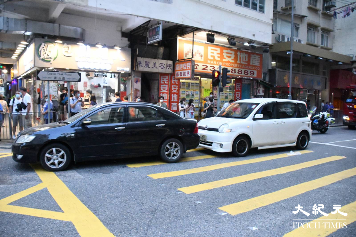 黑色私家車沿青山道右轉入長發街時，尾隨的白色私家車收掣不及。（麥碧／大紀元)