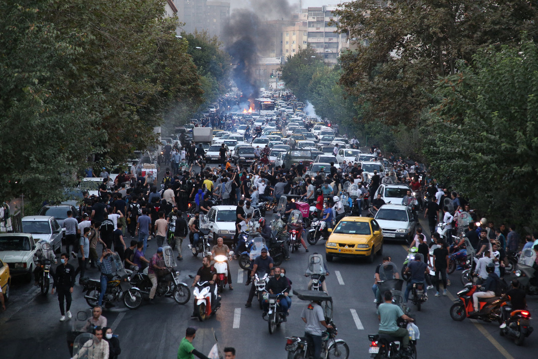 2022年9月21日，法新社在伊朗境外獲得的一張照片顯示，伊朗示威者在年輕女子阿米尼死於警察拘留期間幾天後走上首都德黑蘭街頭。 抗議活動在一夜之間蔓延到伊朗全國15個城市，警方使用武力鎮壓抗議活動並逮捕抗議者。（AFP）