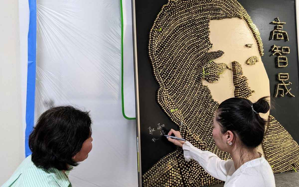 2022年8月13日，耿格（右）在「高智晟浮雕」上簽名。