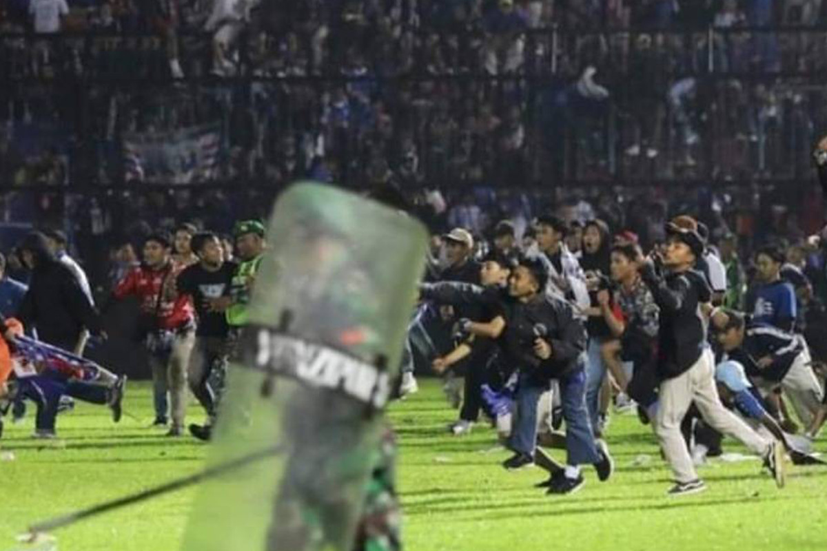 防暴警員衝入球場追打球迷，同時亦施放催淚氣體。 （網絡影片截圖）