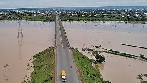 9月25日，在尼日利亞東北部阿達馬瓦州的努曼社區，卡車載著當地居民遠離不斷上漲的洪水。（AFP）