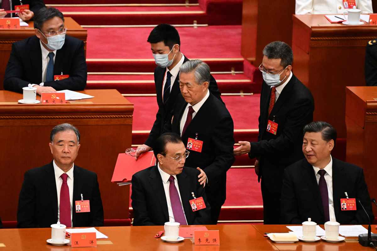 2022年10月22日，在中共二十大閉幕式上，前中共黨魁胡錦濤疑似被強行「勸離」會場。圖為他經過李克強身邊時拍了一下他的肩膀。（Noel CELIS / AFP）