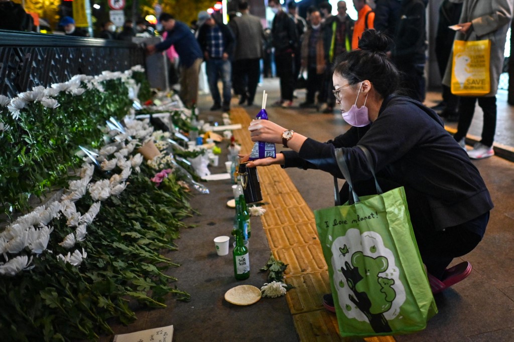 首爾繼市民前往梨泰院的地鐵站外獻花悼念遇難者。（Anthony WALLACE / AFP）