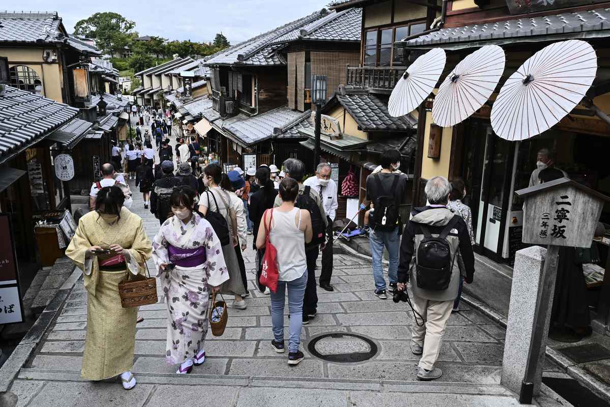 2022年10月13日，遊客們走在一條通往京都清水寺的小巷裏，兩旁是旅遊商店和餐館。（Richard A. Brooks / AFP）
