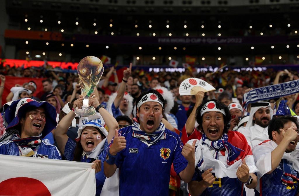 12月1日的世界盃比賽中，日本隊擊敗西班牙隊，以小組頭名闖入十六強。圖為賽後日本球迷慶祝勝利。（Adrian DENNIS / AFP）
