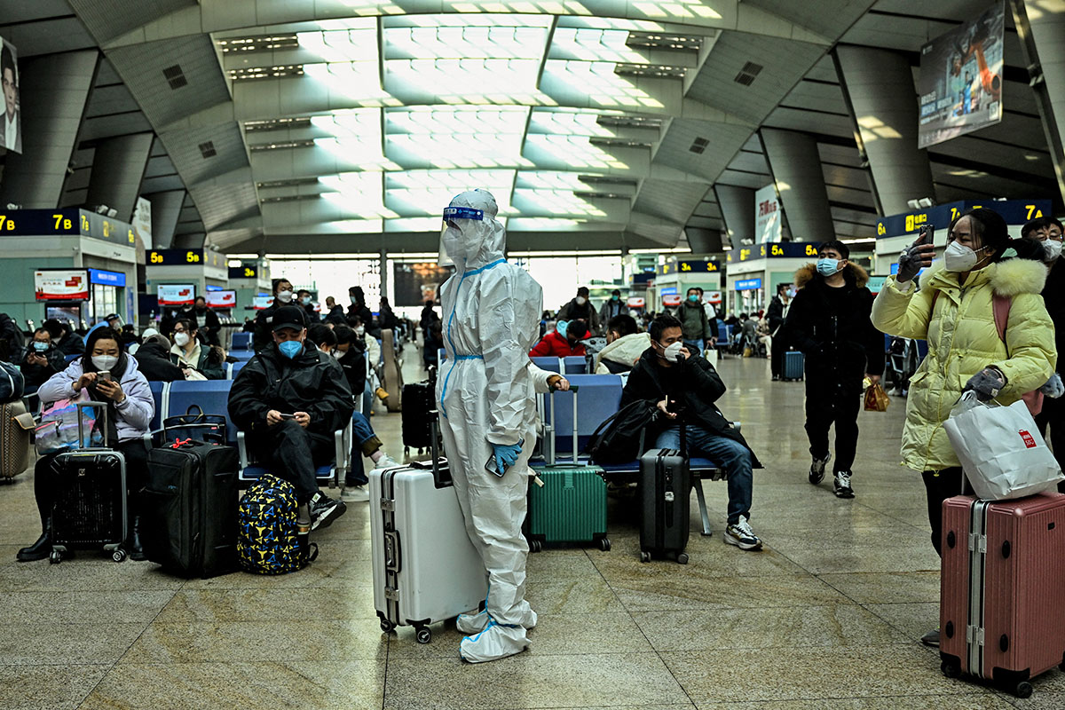 2022年12月28日，一名身穿防護服的乘客在北京火車站。(Noel CELIS / AFP)