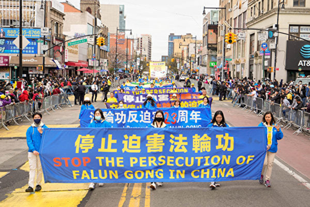 圖為2022年4月法輪功學員在紐約法拉盛遊行打出「停止迫害法輪功」的橫幅。（戴兵/大紀元）