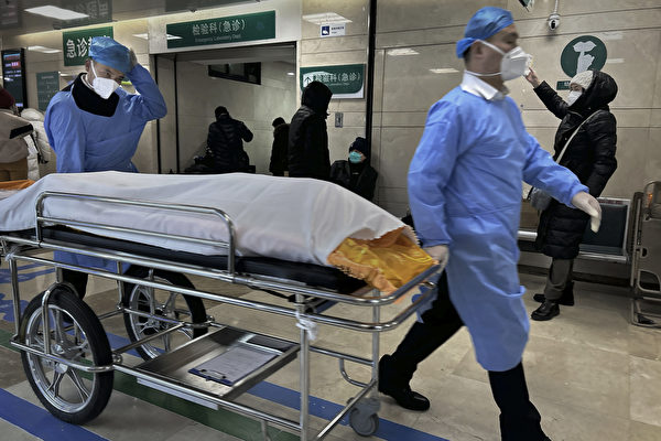2023年1月2日，在中國北京一家繁忙的醫院，醫院工作人員在急症室旁用輪床推送一具屍體。中國的中共病毒（新冠）病例激增，許多城市爆發嚴重疫情。（Getty Images）