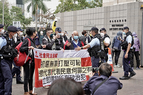 社民連3人請願，但被大批警員包圍並帶到另一邊的「示威區」。（余鋼／大紀元）