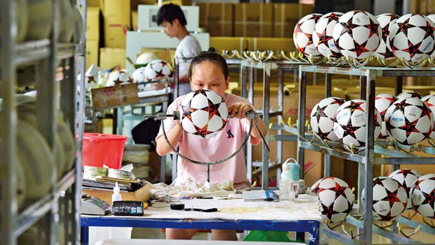 浙江義烏市一家生產足球的外貿工廠，工人們在加班製作海外客戶的足球訂單。(AFP via Getty Images)