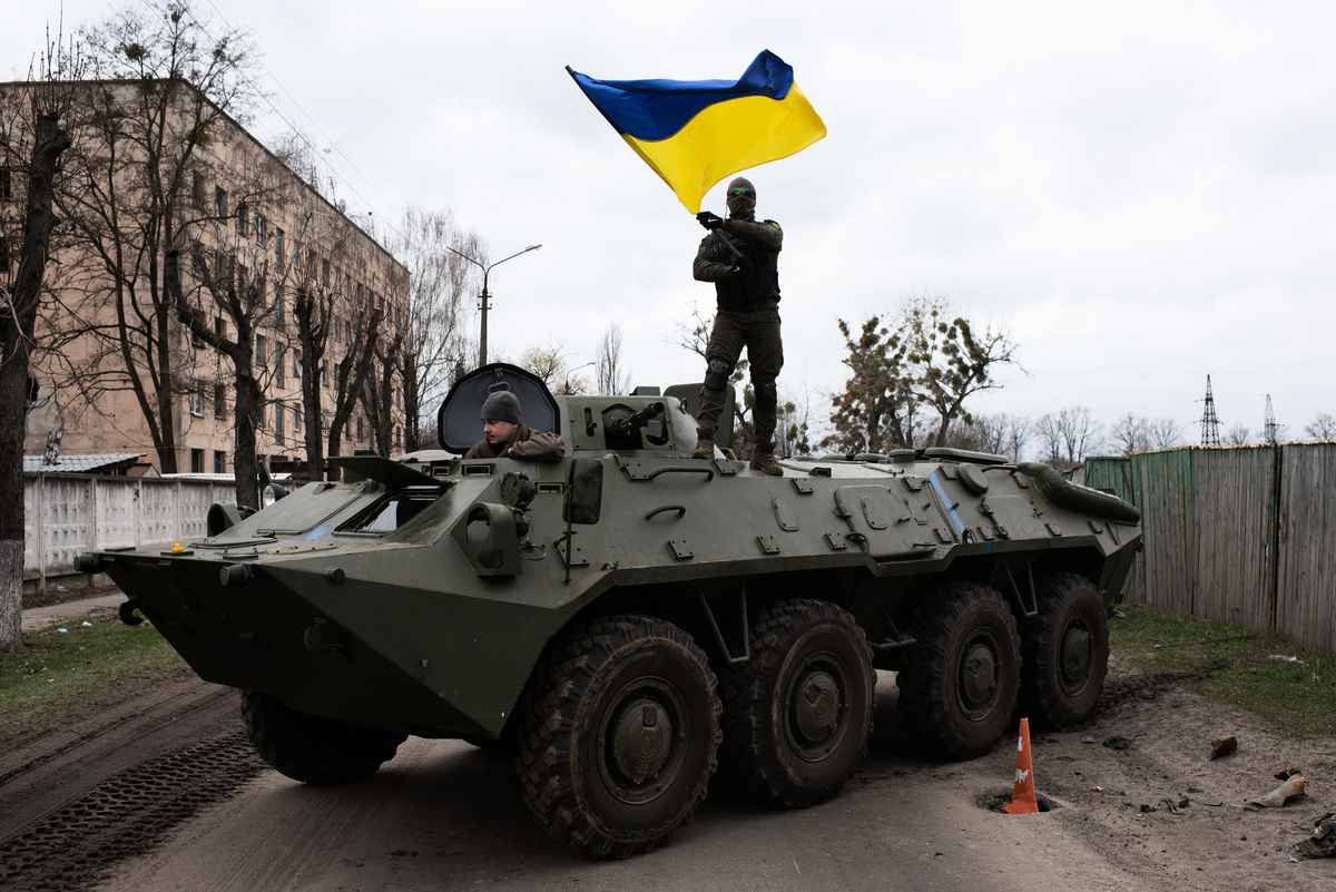 2022年4月8日，烏克蘭士兵站在裝甲運兵車上揮動烏克蘭國旗。（Alexey Furman/Getty Images）