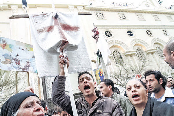 2011年1月1日，埃及港口城市亞歷山大的Al-Qiddissine 教堂遭到汽車炸彈襲擊，造成21人死亡，埃及基督徒在該教堂外進行抗議。（MOHAMMED ABED/AFP via Getty Images）