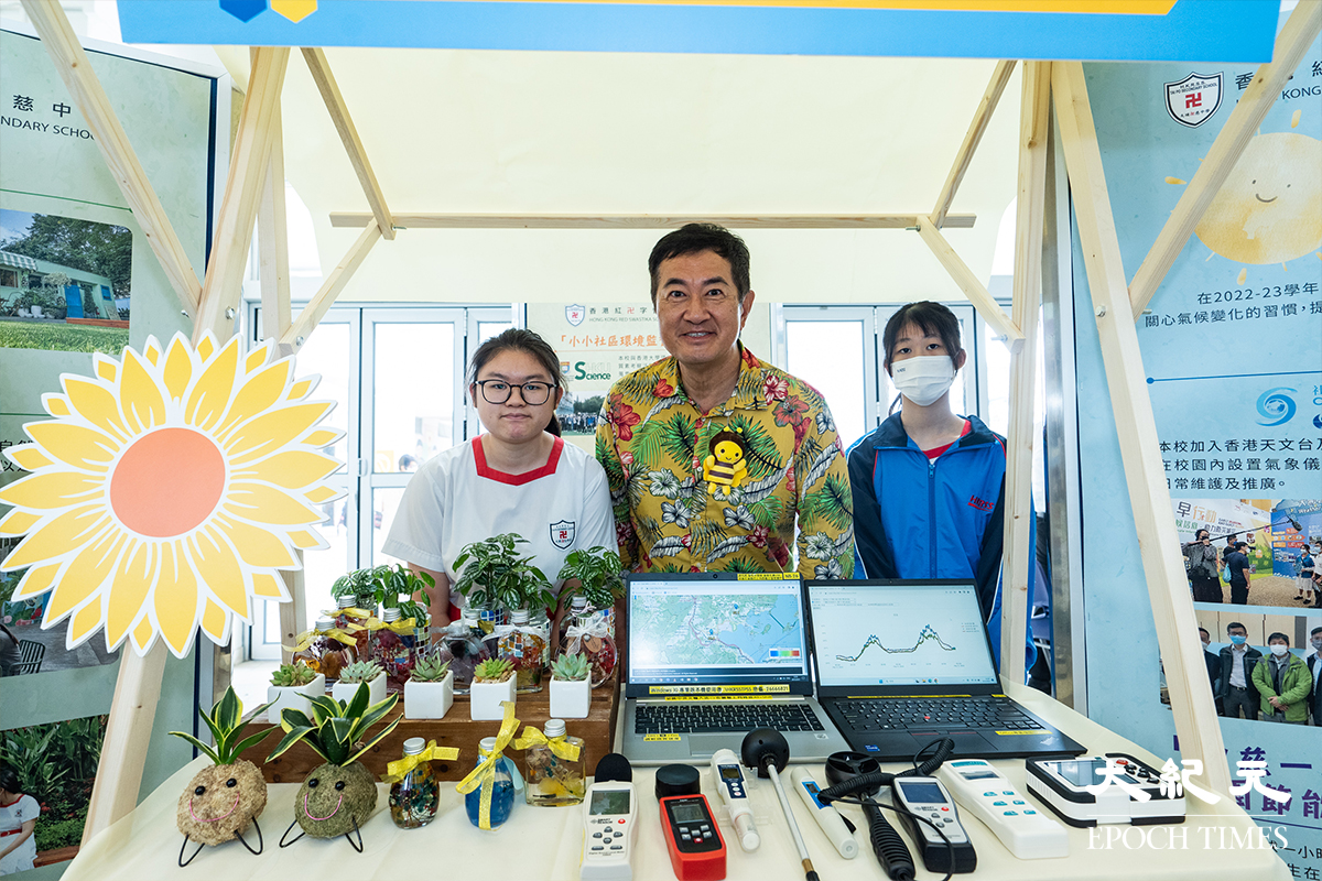 「520世界蜜蜂日體驗展」活動包括8所學校的「永續成果」展覽，圖為鄧梓峰（中）與香港紅卍字會大埔卍慈中學學生合照。（劉駿軒／大紀元）